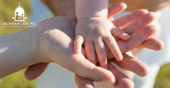 closeup of hands of a family piled together