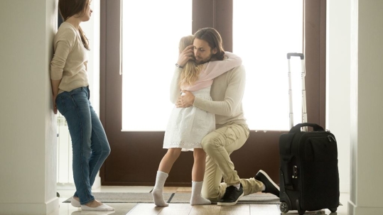 separating parents hugging a child