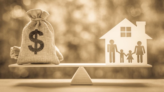 scale balancing a bag of money and an image of a family home